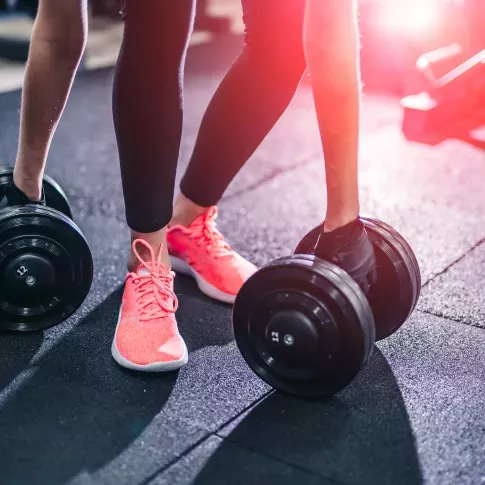 Sport workout exercises with dumbbells. Young woman training in a fitness center