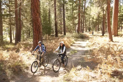 Couple Cycling Through Fall Woodland